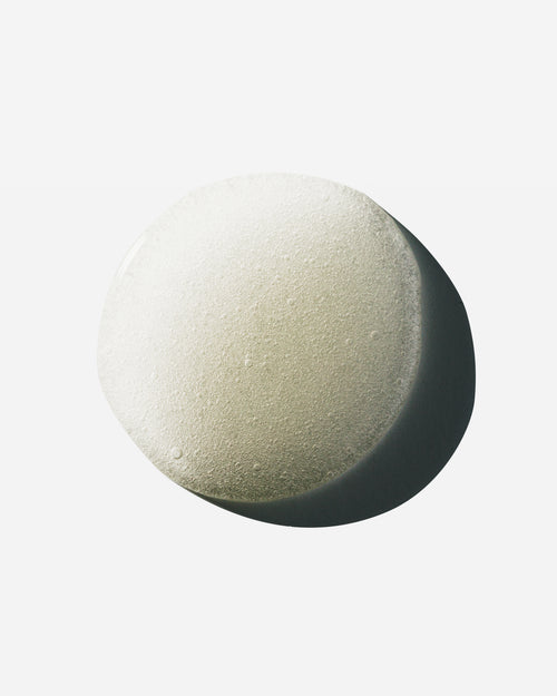 Droplet of Hypertrophy thickening hair treatment serum showing tiny bubbles on a white surface.