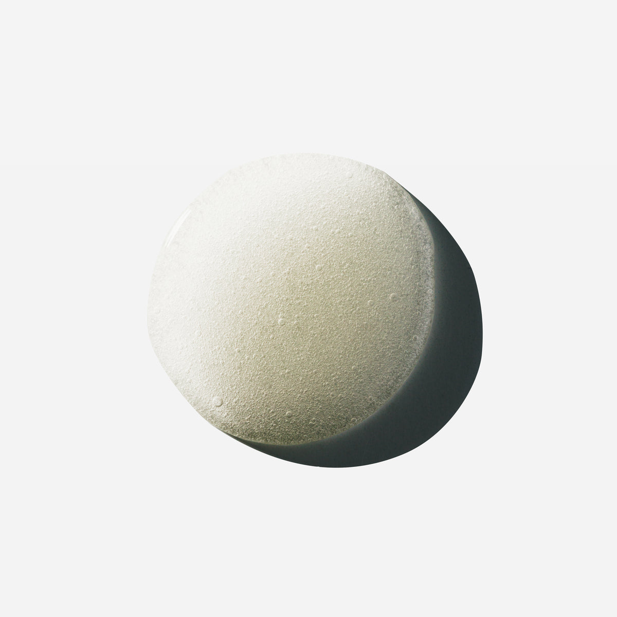 Droplet of Hypertrophy thickening hair treatment serum showing tiny bubbles on a white surface.