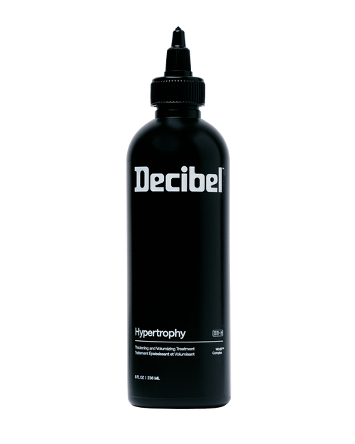 Decibel Hypertrophy thickening and volumizing treatment black bottle on a transparent background.