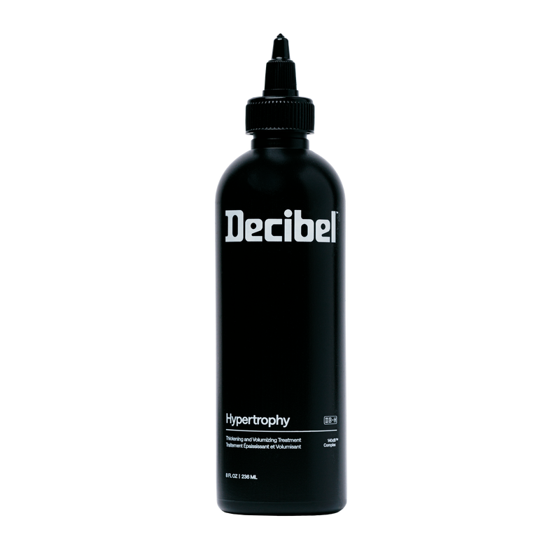Decibel Hypertrophy thickening and volumizing treatment black bottle on a transparent background.